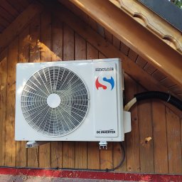 FANTHERM - Zamontowana jednostka zewnętrzna klimatyzacji Sinclair na drewnianej elewacji budynku w Krakowie, widoczne przewody i elementy montażowe.