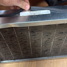 Makowski Group Energy - Brudny filtr wentylacyjny ISO ePM1 60% (F7) z widoczną etykietą i dłonią, leżący na podłodze. Filtr wymaga wymiany lub czyszczenia.