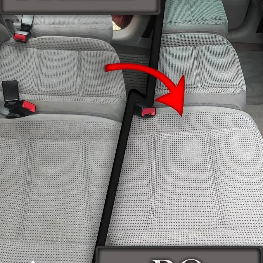 Szare, teksturowane siedzenia samochodowe z czerwonymi klamrami pasów bezpieczeństwa i strzałką wskazującą kierunek.