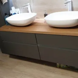 Stylowa szafka umywalkowa z blatem drewnianym i czterema szufladami.