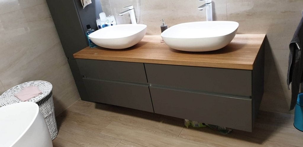 Stylowa szafka umywalkowa z blatem drewnianym i czterema szufladami.