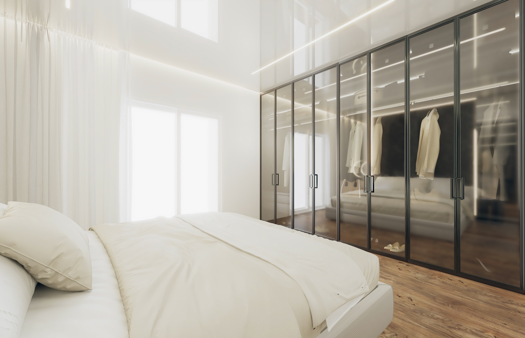Jasna sypialnia z dużą szafą z przesuwnymi, szklanymi drzwiami, w której widać ubrania, oraz z łóżkiem w neutralnych barwach.