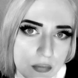 Portret kobiety z mocnym makijażem oczu i blond włosami, zdjęcie czarno-białe z bliska.