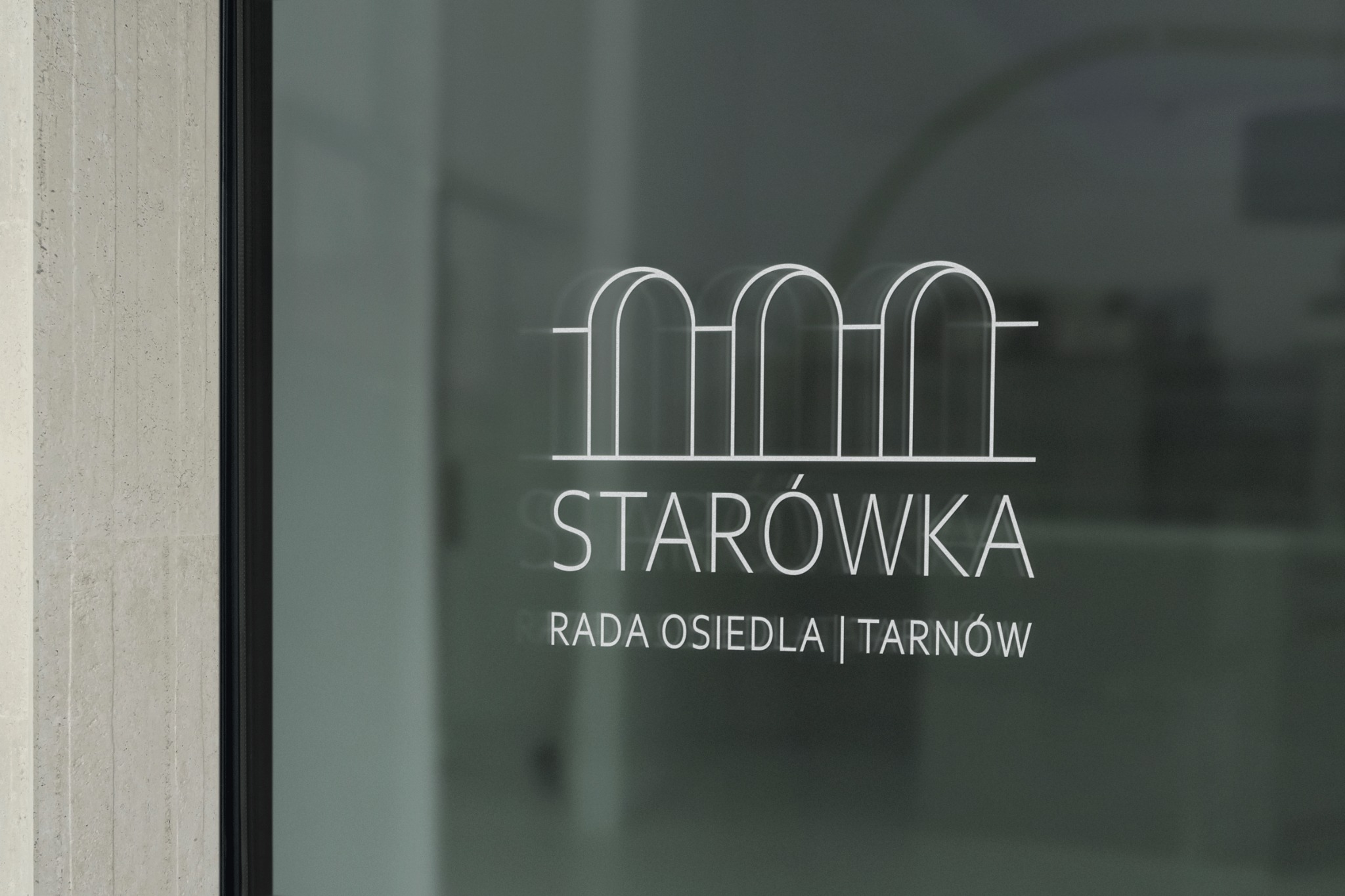 Białe, minimalistyczne logo na szklanej powierzchni przedstawiające stylizowany zarys budynków oraz napis 'STARÓWKA RADA OSIEDLA | TARNÓW'.