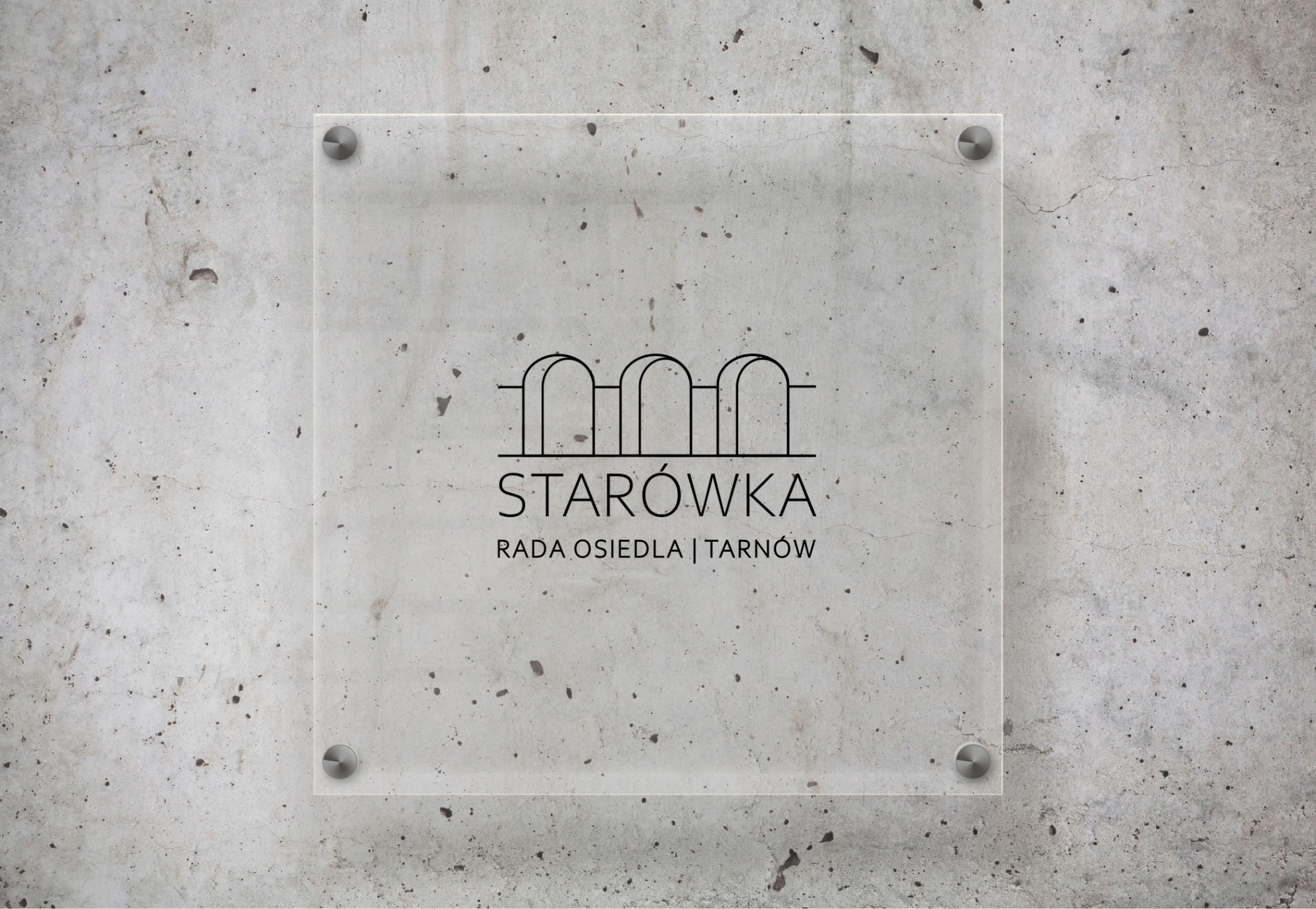 Szklana tablica informacyjna z minimalistycznym logo i napisem 'Starówka Rada Osiedla Tarnów' zamocowana na surowej, betonowej ścianie za pomocą metalowych śrub dystansowych.