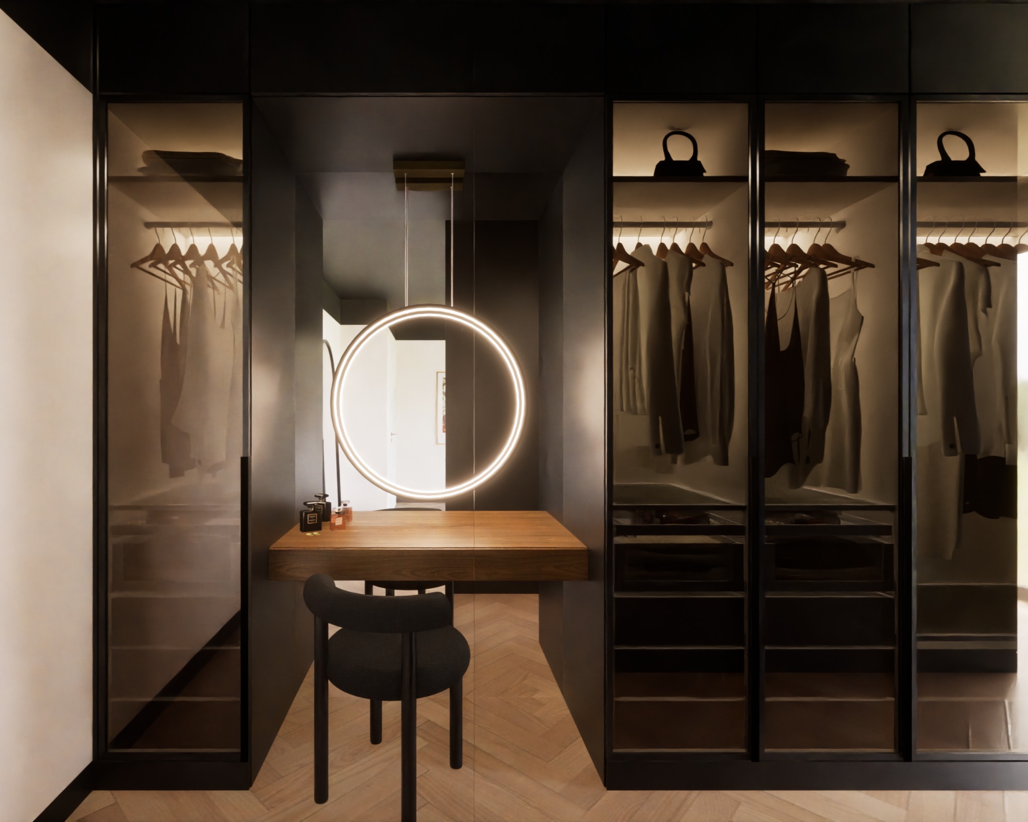 Nowoczesna garderoba z przeszklonymi frontami, podświetlana okrągłym lustrem nad drewnianą toaletką z czarnym krzesłem, na podłodze parkiet w jodełkę.