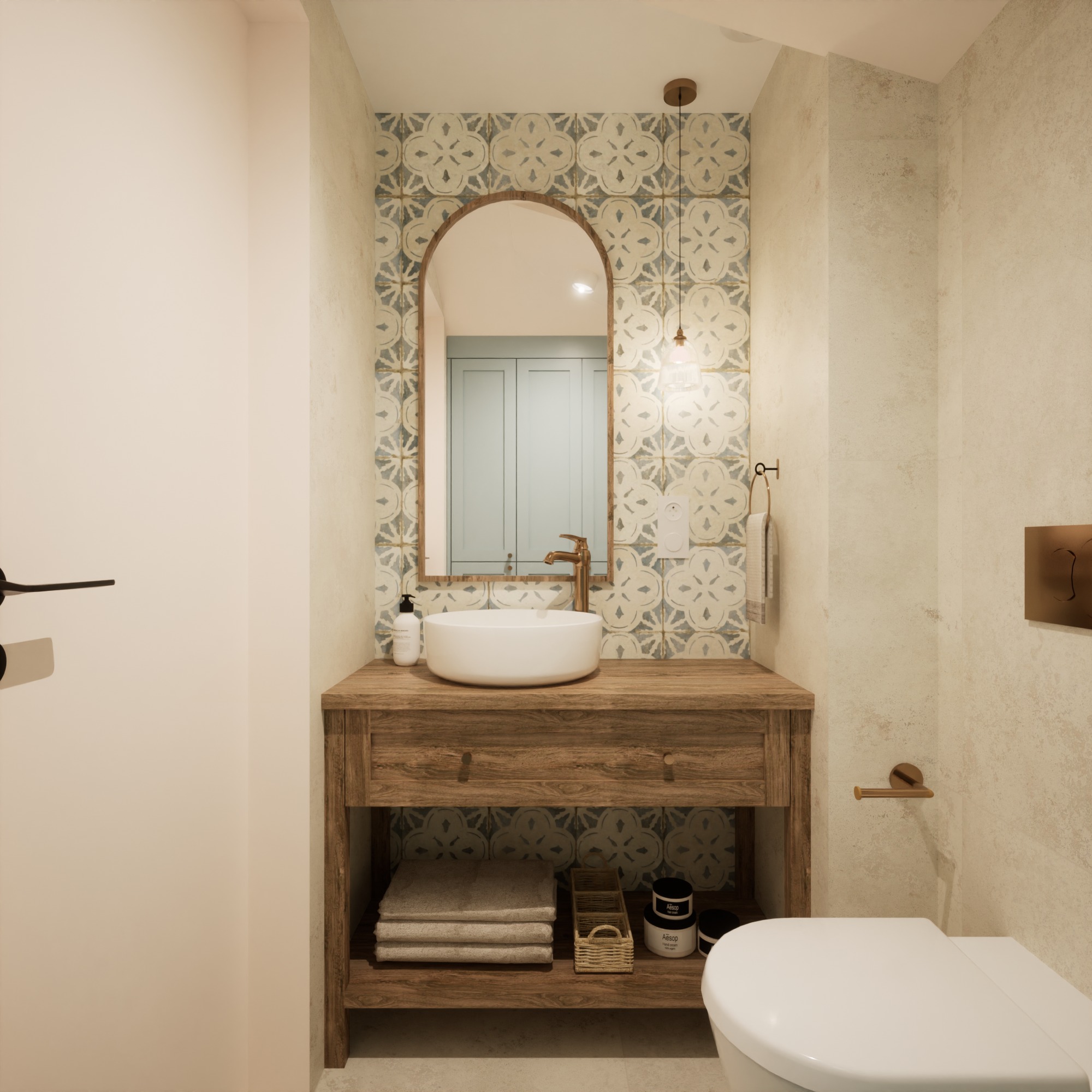 Rustykalna łazienka z drewnianą szafką pod umywalką, okrągłą białą umywalką nablatową i lustrem w kształcie łuku na tle dekoracyjnych płytek.