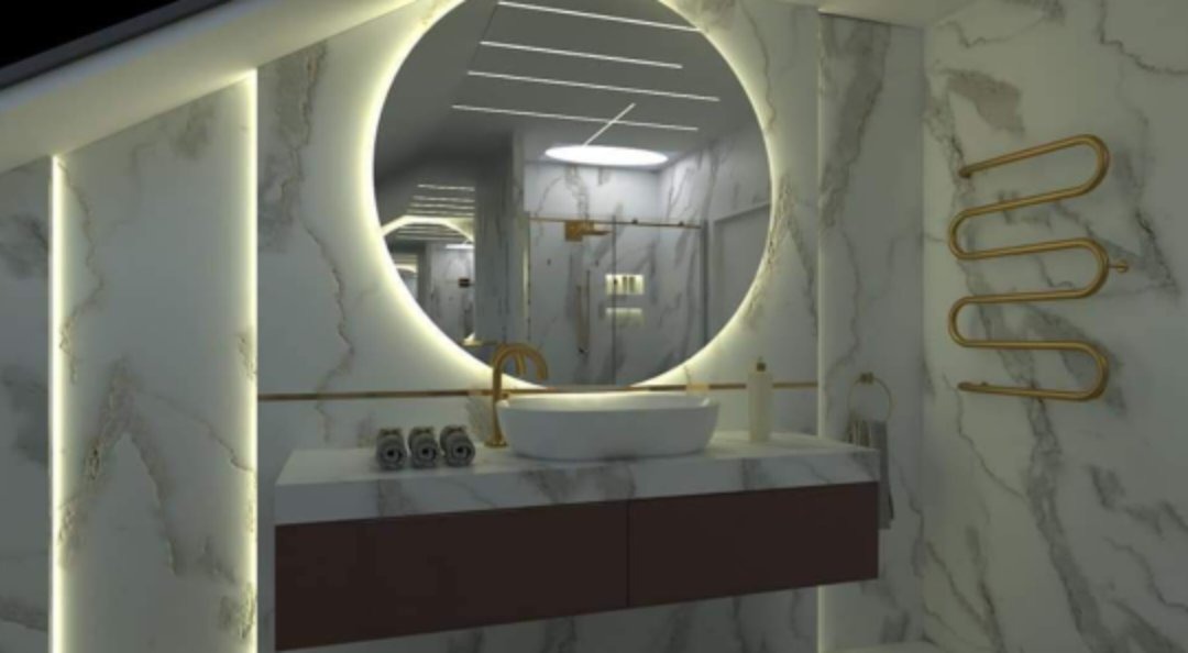 Elegancka łazienka z marmurowymi ścianami, okrągłym lustrem z podświetleniem LED, owalną umywalką nablatową, złotą armaturą i grzejnikiem drabinkowym w kolorze złota.