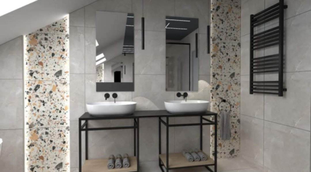 Nowoczesna łazienka z dwoma umywalkami nablatowymi, czarnymi armaturami i grzejnikiem drabinkowym. Ściany wyłożone płytkami w dwóch wzorach: gładkie szare i mozaika lastryko. Nad umywalkami wiszą...