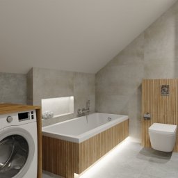 Mo-Kam bud - Nowoczesna łazienka na poddaszu z pralką z drewnianym blatem, wanną obudowaną drewnianymi lamelami z podświetleniem LED, toaletą wiszącą na drewnianym panelu i umywalką z szafką w odcieniach szarości.