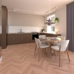 Pracownia Misja Wnętrze - Jasna kuchnia z drewnianymi szafkami, parkietem w jodełkę i okrągłym stołem z krzesłami. Minimalistyczny design z wiszącą lampą i roślinami.