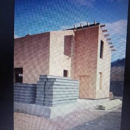 Firma ogólnobudowlana Rafał Adamczewski - Surowy stan dwukondygnacyjnego domu szkieletowego z widocznymi panelami izolacyjnymi na fundamencie, w tle błękitne niebo.