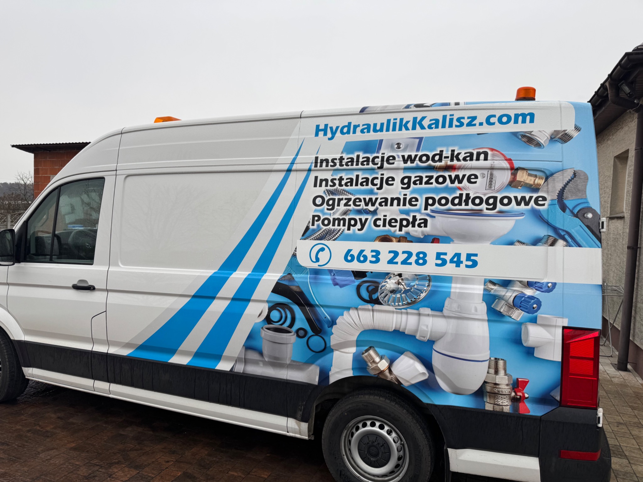Biały van z niebieską grafiką: instalacje wod-kan, gazowe, ogrzewanie podłogowe, pompy ciepła. Kontakt: HydraulikKalisz.com, numer telefonu. Elementy instalacyjne w tle.