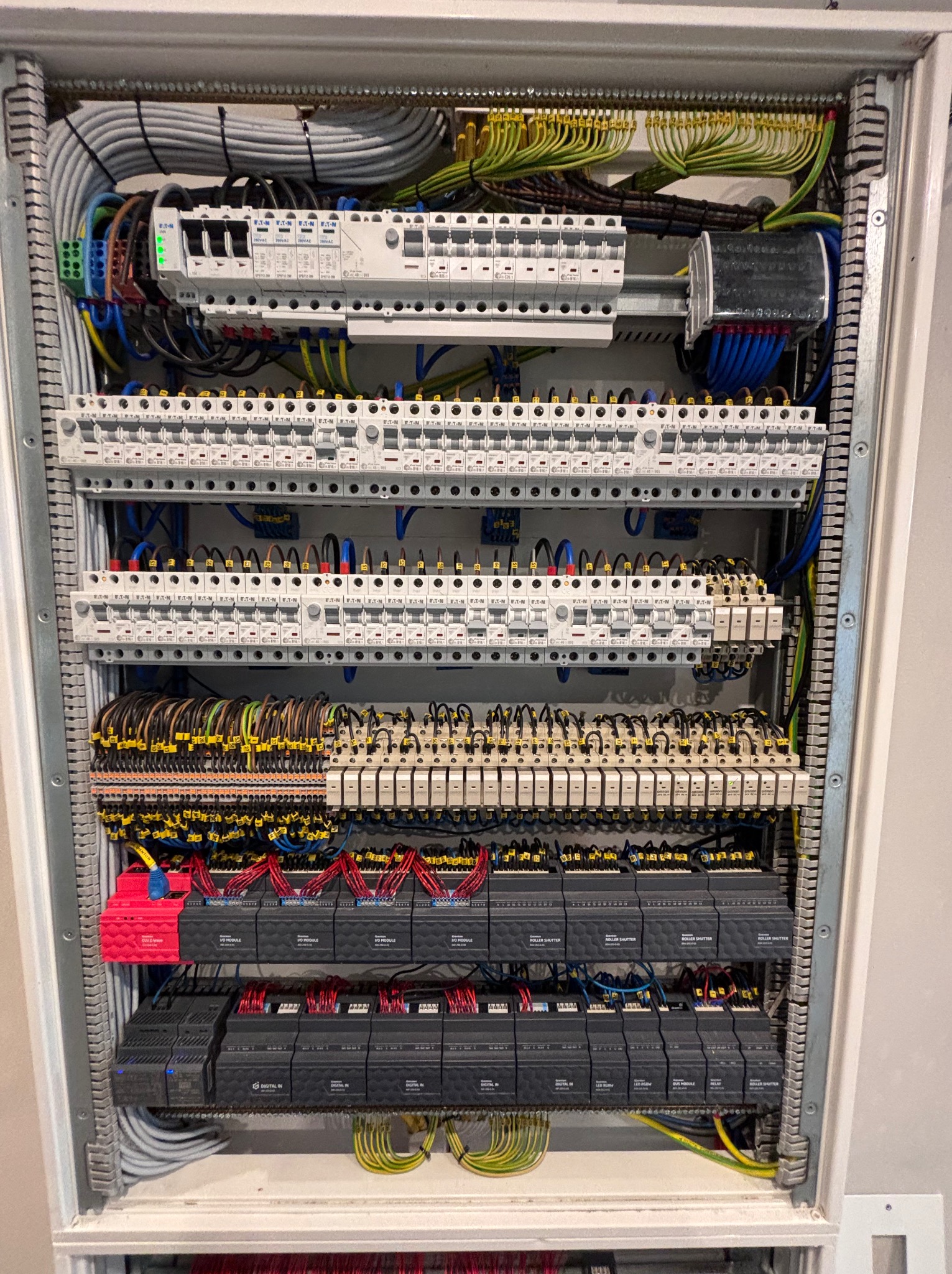 Rozdzielnica elektryczna z modułami, bezpiecznikami i okablowaniem wewnątrz szafy. Widoczne elementy automatyki i sterowania.
