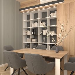 Materia design studio - Nowoczesne biuro z drewnianym stołem, szarymi krzesłami, regałem z książkami i klimatyzacją na ścianie.