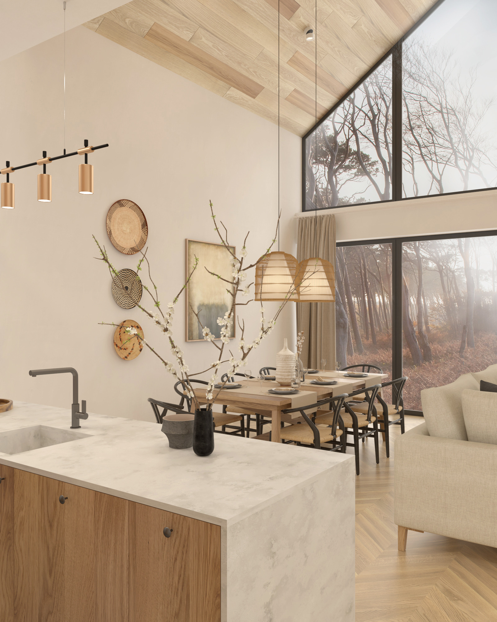 Jasne wnętrze z drewnianą podłogą w jodełkę, wyspą kuchenną z szarym blatem, stołem jadalnym z krzesłami z rattanu i widokiem na las przez duże okno.