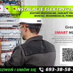 Elektryk w kasku i okularach ochronnych, z żółtym śrubokrętem w dłoni, pracuje przy rozdzielnicy elektrycznej. Widoczny napis 'INSTALACJE ELEKTRYCZNE' oraz logo 'Grenton SMART HOME'.