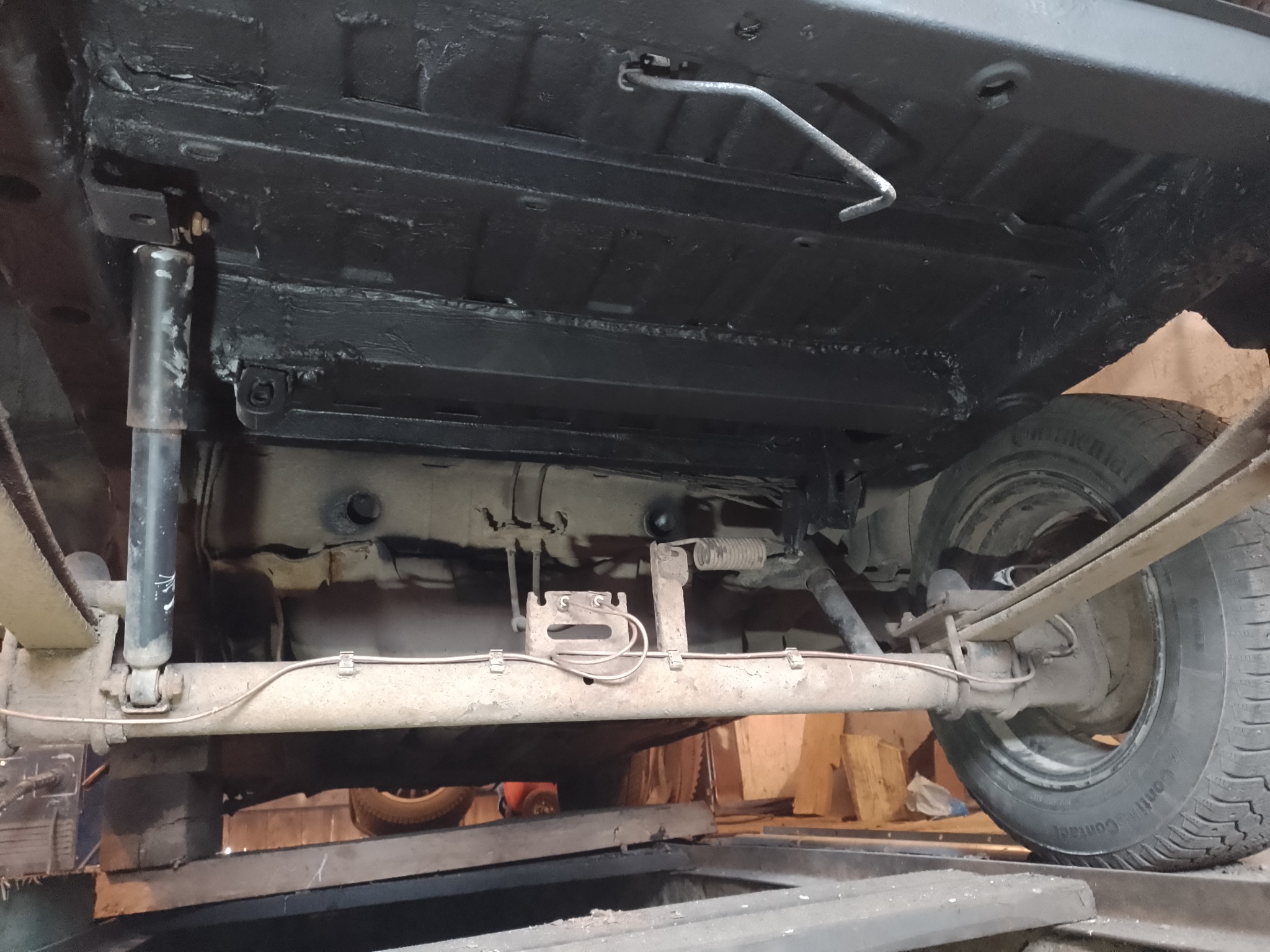 Podwozie samochodu po zabezpieczeniu antykorozyjnym, widoczne elementy zawieszenia, amortyzatory i opony Continental Contact.