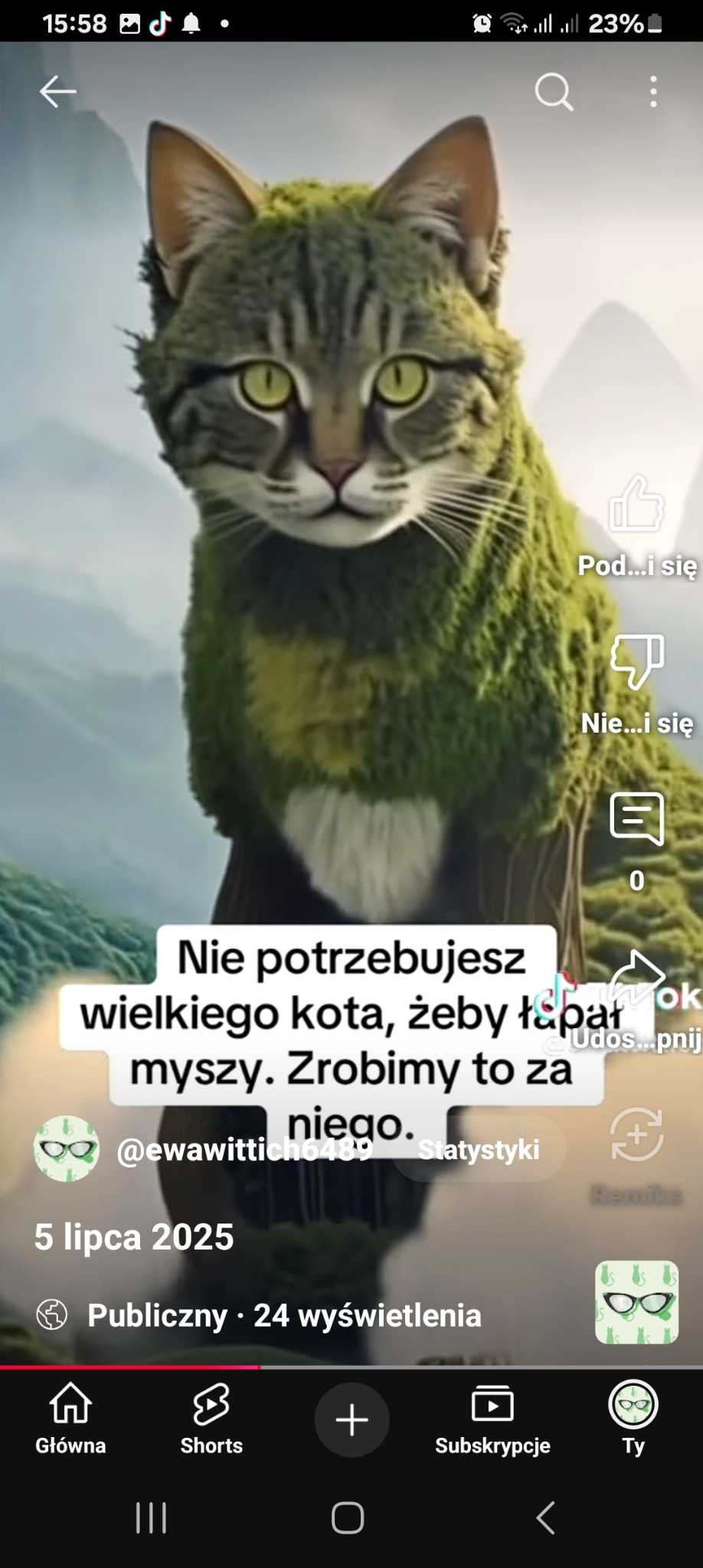 Grafika przedstawia kota z zielonym futrem przypominającym mech, na tle gór. Widoczne elementy interfejsu aplikacji mobilnej.