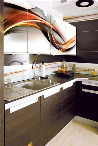 Ciemnobrązowe szafki kuchenne z białymi uchwytami i górnymi szafkami z abstrakcyjnym wzorem w kolorach pomarańczowym, szarym i białym, widok na zlew i blat.