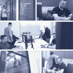 Zespół w biurze agencji interaktywnej Zdobywcy Sieci: pracownicy przy laptopach, rozmowy, logo firmy na szklanych drzwiach, mężczyzna w windzie.