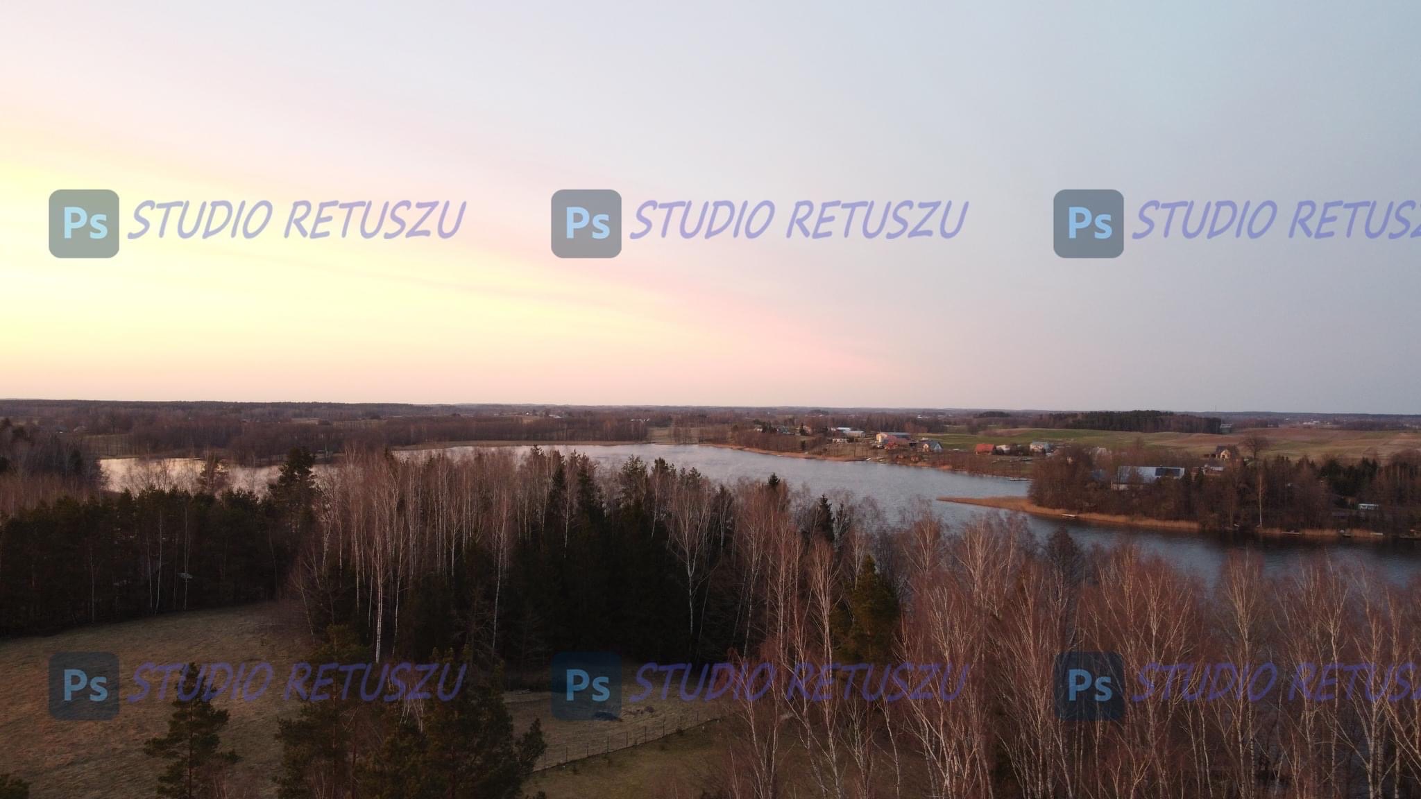 Pejzaż jeziora o zmierzchu z widocznymi drzewami i polami, znak wodny 'Ps STUDIO RETUSZU' nałożony na obraz.
