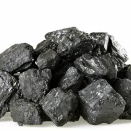 Kupa błyszczącego, czarnego węgla na białym tle, z widocznymi naturalnymi pęknięciami i nierównościami w strukturze.