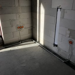 instalacja prowadzona w podłodze oraz tunel służący do przeprowadzenia przewodów/wtyczek z listwy przypodłogowej za telewizor 