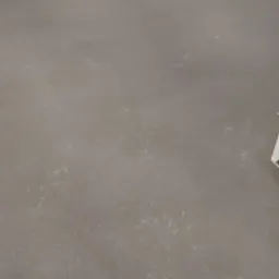 Świeżo wylana, gładka, szara posadzka w pomieszczeniu z białymi ścianami z bloczków betonowych. Widoczne ślady po narzędziach do rozprowadzania masy.