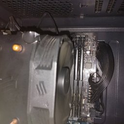 Odmulacz.pl - Wnętrze obudowy komputera z zamontowanym dużym radiatorem procesora z wentylatorem, widoczne kości pamięci RAM i uporządkowane kable zasilające.