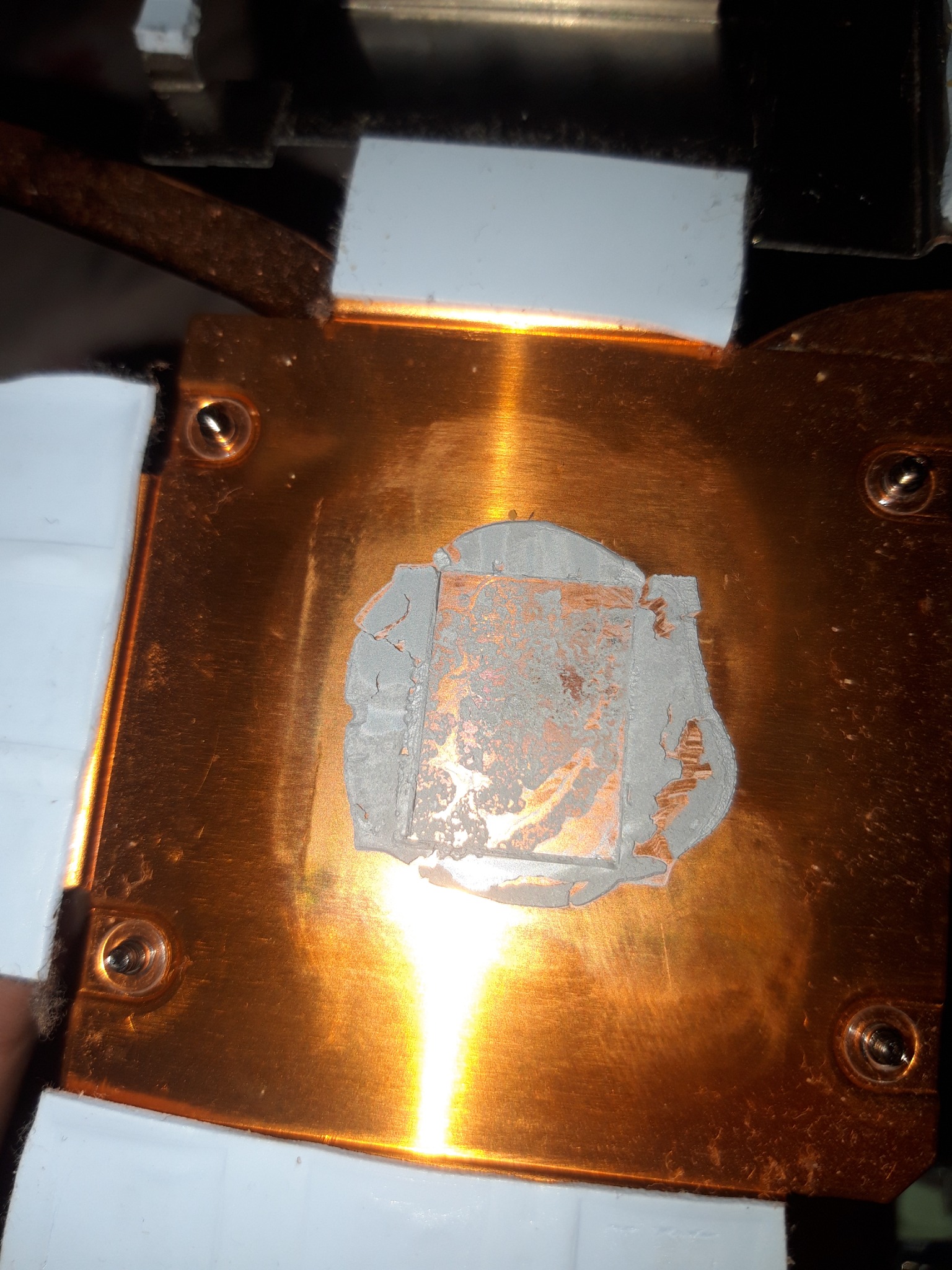 Miedziany radiator procesora z resztkami starej pasty termoprzewodzącej, przygotowany do nałożenia nowej warstwy.