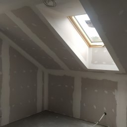 Stanislav Vorontsov - Poddasze po montażu płyt karton-gips z oknem dachowym i wystającymi przewodami elektrycznymi, przygotowane do dalszych prac wykończeniowych.