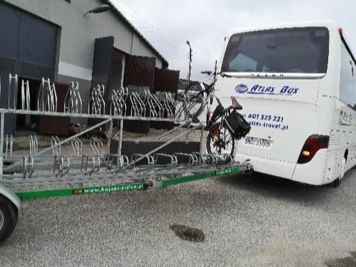 Autokar Atlas Bus z przyczepą rowerową i rowerem na haku, widok z tyłu na szarym tle parkingu