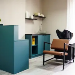 Recepcja i stanowisko do mycia włosów w salonie fryzjerskim w Bytowie, z szafkami w kolorze morskim i drewnianym krzesłem.