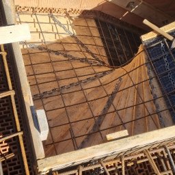 Ivan Polianskyi - Zbrojenie pod wylewkę schodów z użyciem drewnianych szalunków i cegieł dziurawki. Widoczne pręty zbrojeniowe i elementy konstrukcyjne. Ujęcie z góry.