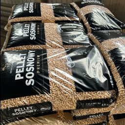 Benefit Partner Marlena Popławska - Stos worków z pelletem sosnowym premium, każdy o wadze 15 kg, z widocznymi oznaczeniami jakości i certyfikatami. Worki ułożone jeden na drugim, wypełnione jasnymi granulkami pelletu.