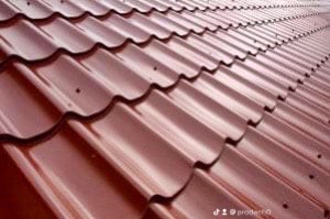 Czerwona blachodachówka ułożona na dachu, widok z dołu pod kątem, widoczne mocowania.