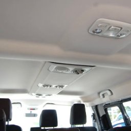 QRC Sławomir Dębinski - Wnętrze busa pasażerskiego: widok na sufit z oświetleniem i nawiewami, czarne zagłówki foteli w tle.