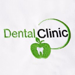Produkt-Kontakt sp. z o.o. - Wyhaftowane logo 'Dental Clinic' na białym materiale, z elementem graficznym zielonego jabłka z białym zębem w środku i zielonym półokręgiem nad napisem.