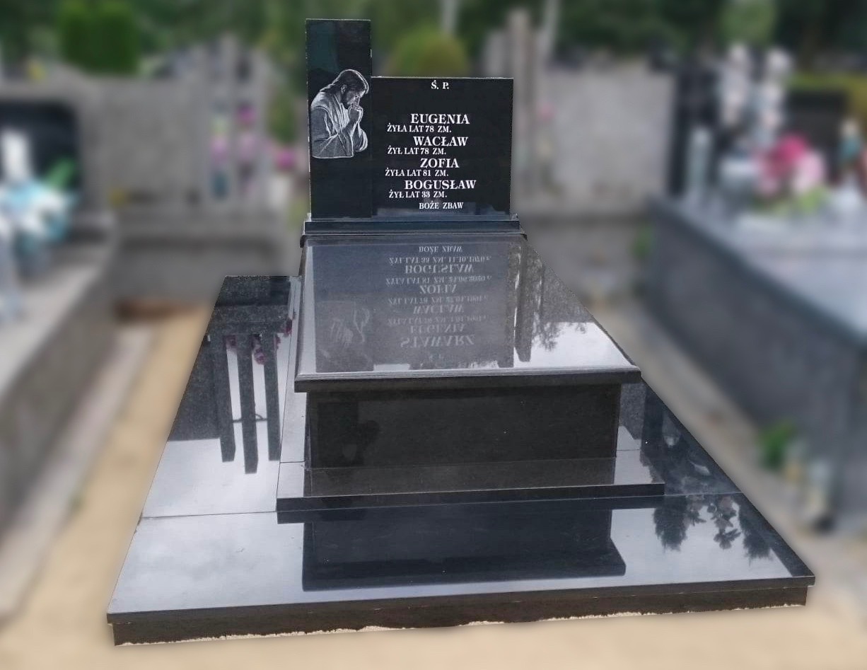 Czarny, dwupoziomowy pomnik z wygrawerowanym wizerunkiem modlącej się osoby, umieszczony na cmentarzu z widocznymi innymi nagrobkami w tle.