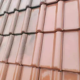 Częściowo umyty dach z ceramicznej dachówki karpiówki w odcieniach brązu, z widoczną różnicą w czystości między umytą a nieumytą częścią dachu.