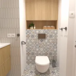 Nowoczesna łazienka z wiszącą toaletą, wzorzystymi płytkami na ścianie i podłodze, szafką nad toaletą oraz umywalką nablatową z drewnianą szafką.