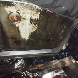 Michał Sobczyk - Podwozie auta po konserwacji antykorozyjnej w Świętochłowicach. Widoczne zabezpieczone elementy i świeża powłoka ochronna. Detal zardzewiałej śruby.