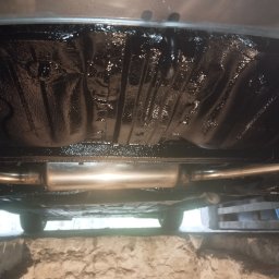 Michał Sobczyk - Podwozie auta po konserwacji antykorozyjnej, widoczny nowy układ wydechowy i zabezpieczone, błyszczące elementy. Auto na podnośniku.