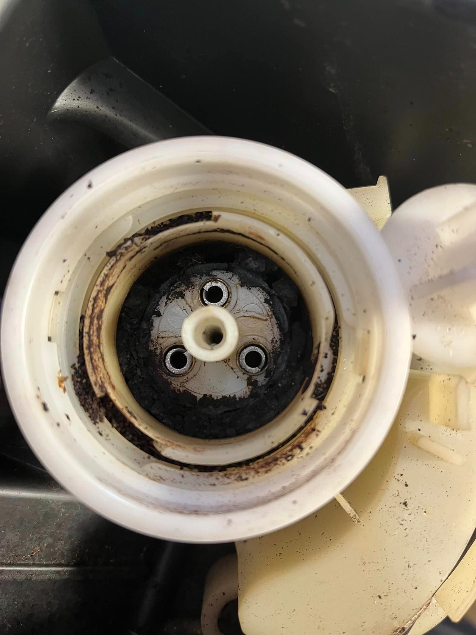 Zanieczyszczony, zużyty filtr do ekspresu z osadami kawy i rdzy, widok z góry.