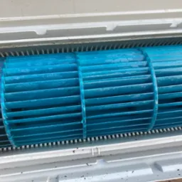 Błękitny, wyczyszczony wentylator bębnowy klimatyzacji w obudowie, widoczne drobne zabrudzenia, usługa czyszczenia klimatyzacji w Uniejowie.