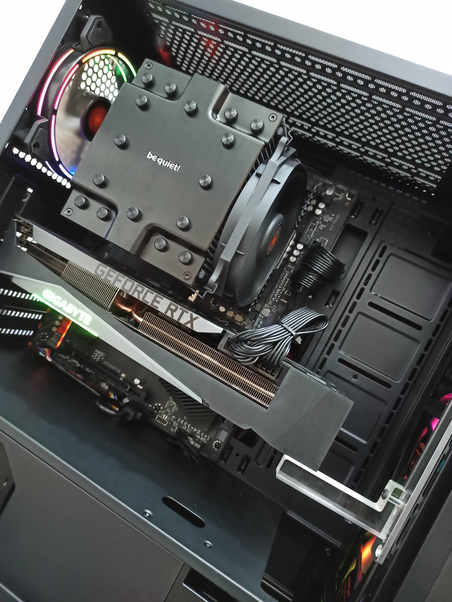 Wnętrze obudowy komputera stacjonarnego z kartą graficzną GeForce RTX, chłodzeniem procesora be quiet! i podświetlanym wentylatorem RGB.