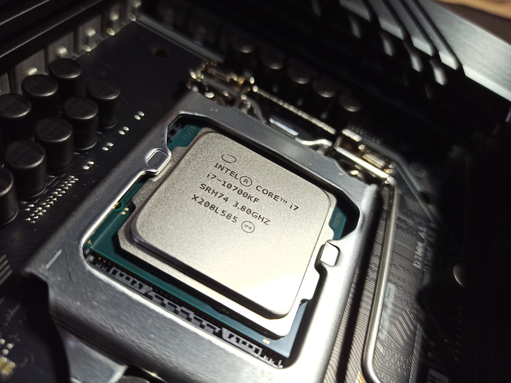 Procesor Intel Core i7-10700KF zamontowany w gnieździe płyty głównej, widoczne oznaczenia modelu i specyfikacja techniczna.