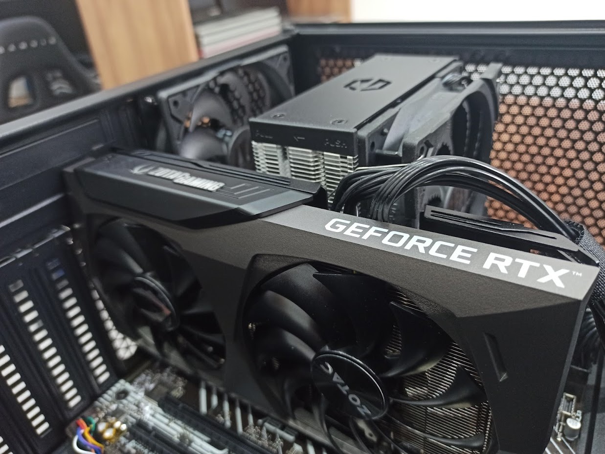 Wnętrze komputera stacjonarnego z zainstalowaną kartą graficzną ZOTAC GeForce RTX, widoczny radiator procesora i wentylatory chłodzące.
