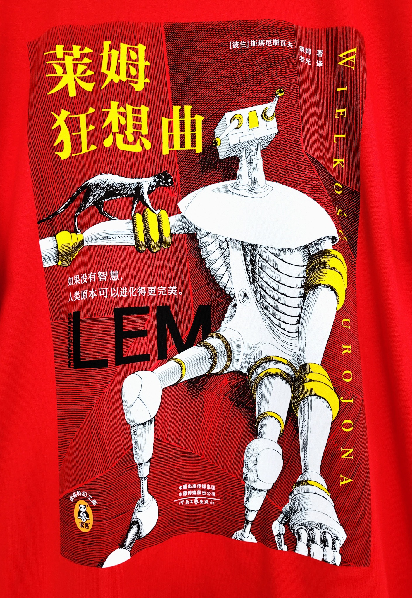 Czerwona koszulka z nadrukiem grafiki inspirowanej twórczością Stanisława Lema, przedstawiającej stylizowanego robota z czarnym zwierzęciem na ramieniu, całość w czarno-biało-żółtej kolorystyce...